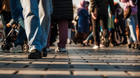 A imagem mostra uma calçada e pessoas andando sobre ela; ilustra o artigo sobre abordagem social.